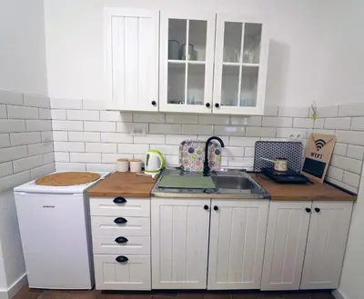 a kitchen with white cabinets and a sink at Kuća Petrovića in Aleksandrovac