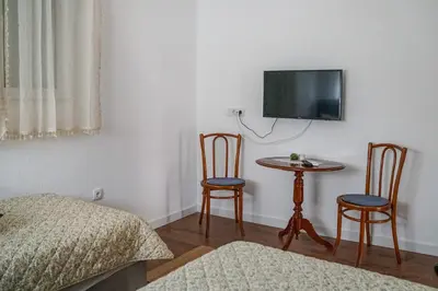 a bedroom with a table and two chairs and a tv at Kuća Petrovića in Aleksandrovac