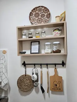 a shelf with utensils and plates on a wall at Apartmani Dragulji Krusevac in Kruševac