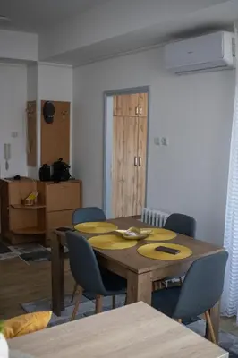 a dining room with a table and some chairs at Apartman Viševac Vranje in Vranje
