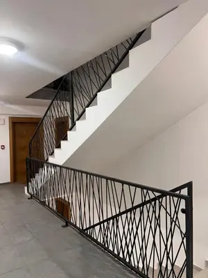 a staircase with black metal railing in a building at Apartman Malićanin in Vrnjačka Banja