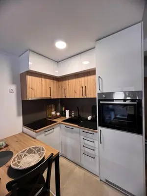 a kitchen with wooden cabinets and a white refrigerator at Apartman Malićanin in Vrnjačka Banja