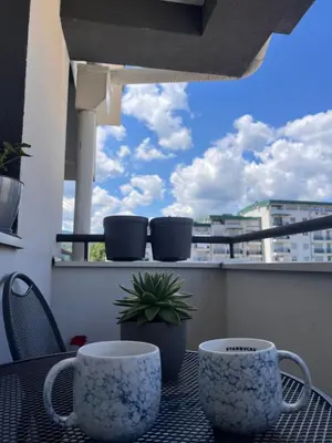 two coffee cups sitting on a table on a balcony at Apartman Malićanin in Vrnjačka Banja