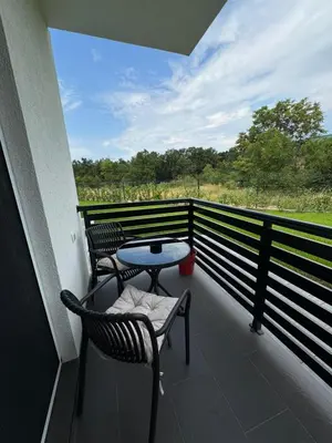 a patio with two chairs and a table on a balcony at Apartmani Luna, Borsko jezero in Bor