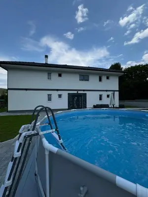 a large swimming pool in front of a house at Apartmani Luna, Borsko jezero in Bor