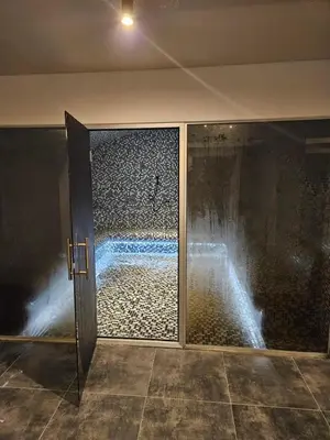 a bathroom with a shower with a glass door at Hop Na Kop Studio Apartman in Kopaonik