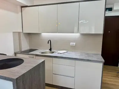 a kitchen with white cabinets and a sink at Royal Apartmani 3 in Paraćin