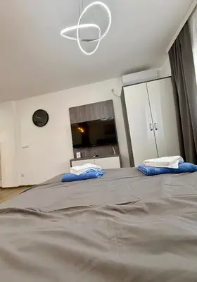 a bedroom with a large bed with two blue pillows at Royal Apartmani 3 in Paraćin
