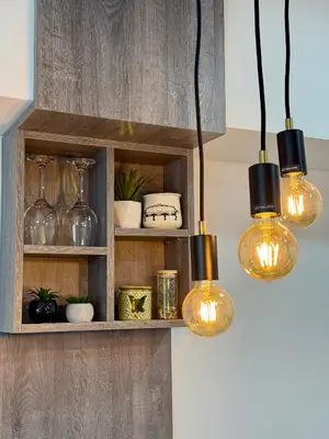 a kitchen with three lights hanging from a shelf at Royal Apartmani 3 in Paraćin