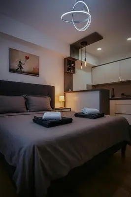 a bedroom with a large bed with two towels on it at Royal Apartmani 3 in Paraćin