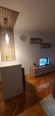 a living room with a television and a table at Studio Inn 