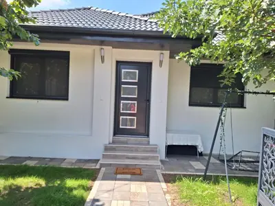 a white house with a black door at Apartmani Park Cuprija in Ćuprija