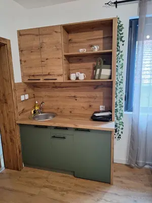 a kitchen with a sink and a wooden cabinet at Apartmani Park Cuprija in Ćuprija