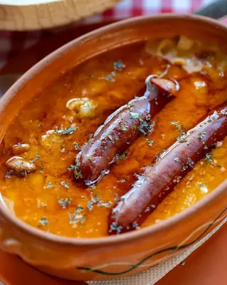 two sausages in a bowl of curry at Lisine Lepo Mesto Guesthouse & Spa in Strmosten
