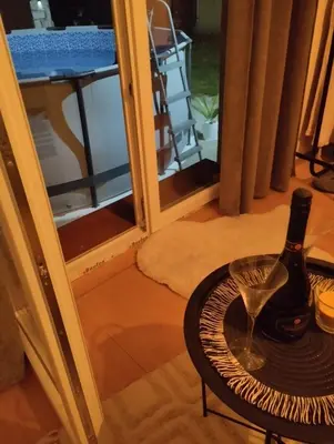 a bottle of wine on a table in front of a door at Apartman Sweet Dreams in Svrljig