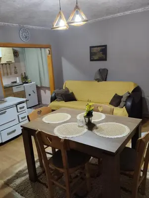 a living room with a table and a couch at Apartman Sweet Dreams in Svrljig