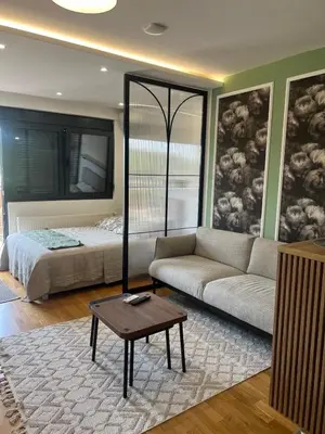 a living room with a couch and a bed at Studio Crnjanski in Jagodina