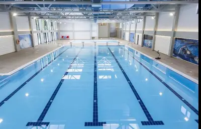 a large indoor swimming pool with blue water at Studio Crnjanski in Jagodina