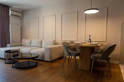a living room with a couch and a table at Planet Imperial Apartman & SPA in Niš