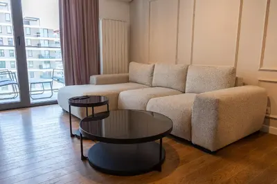 a living room with a couch and two tables at Planet Imperial Apartman & SPA in Niš