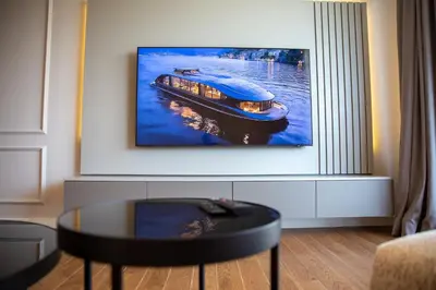 a living room with a picture of a boat on the water at Planet Imperial Apartman & SPA in Niš