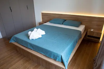 a bed with two stuffed animals sitting on it at Planet Imperial Apartman & SPA in Niš