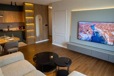 a living room with a large flat screen tv on a wall at Planet Imperial Apartman & SPA in Niš