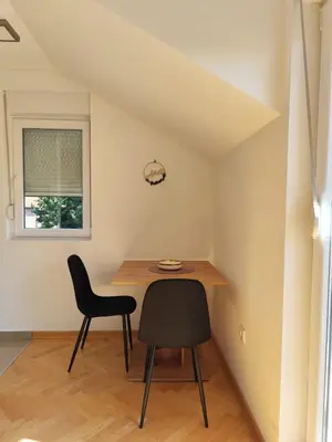 a small dining room with a table and two chairs at Raj M&M in Vrnjačka Banja