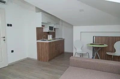 a living room with a kitchen and a table at Niš City Center Guest House in Niš