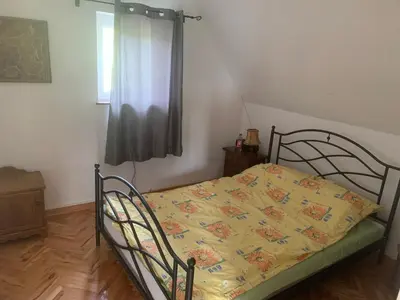 a bedroom with a bed with a yellow blanket on it at Kuća Sokolovića in Zaječar