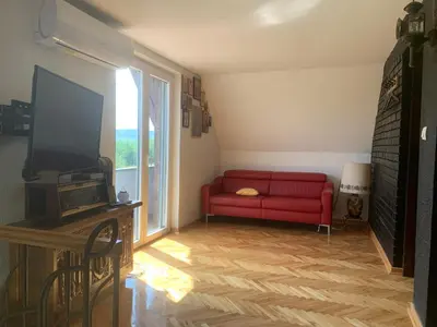 a living room with a red couch and a television at Kuća Sokolovića in Zaječar