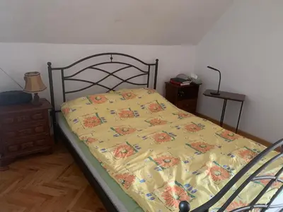 a bed with a yellow comforter in a bedroom at Kuća Sokolovića in Zaječar