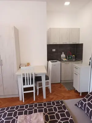 a kitchen with a white table and chairs in a room at Apartmani Bata I Seka in Vrnjačka Banja