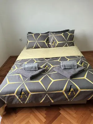 a bed with two pillows on top of it at Apartmani Bata I Seka in Vrnjačka Banja