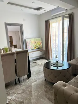 a living room with a couch and a table and chairs at L apartmani in Soko Banja