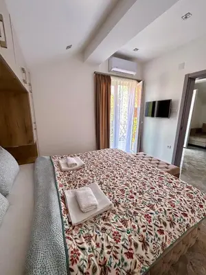 a bedroom with a large bed with two towels on it at L apartmani in Soko Banja