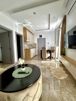 a living room with a table and a kitchen at L apartmani in Soko Banja