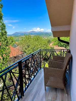 a balcony with two chairs and a view at L apartmani in Soko Banja
