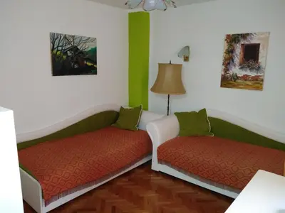 two beds in a room with green and white walls at Apartmani Lucky in Vrnjačka Banja