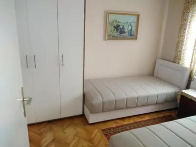 a small bedroom with a bed and a cabinet at Apartmani Lucky in Vrnjačka Banja