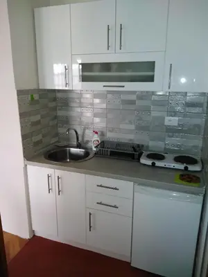 a kitchen with white cabinets and a sink at Apartmani Lucky in Vrnjačka Banja