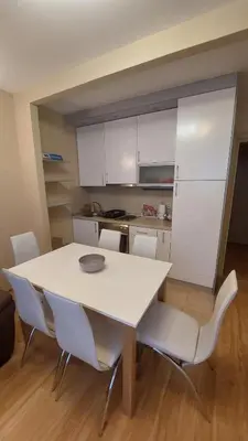 a kitchen with a white table and white chairs at Apartman Dona in Jagodina