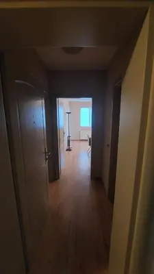 an empty room with a hallway leading to a room with a table at Apartman Dona in Jagodina