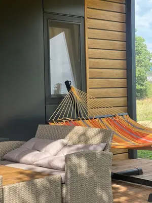 a hammock on a patio next to a window at Vrnjačko Vrelo Resort in Novo Selo