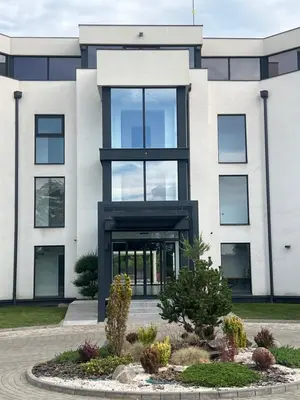 a large white building with a large window at Vrnjačko Vrelo Resort in Novo Selo