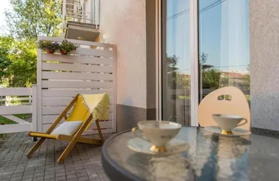 a balcony with a table and a chair and a window at Dvoristance in Vrnjačka Banja