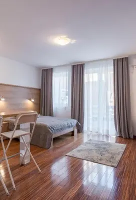a bedroom with a bed and a chair in a room at Dvoristance in Vrnjačka Banja
