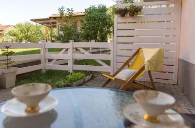 a patio with a table and a chair and a fence at Dvoristance in Vrnjačka Banja