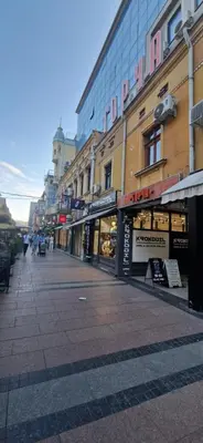 an empty city street with shops and buildings at Urban Nest Nis in Niš