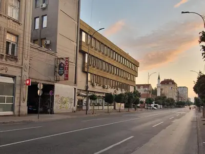 an empty street in a city with a building at Urban Nest Nis in Niš